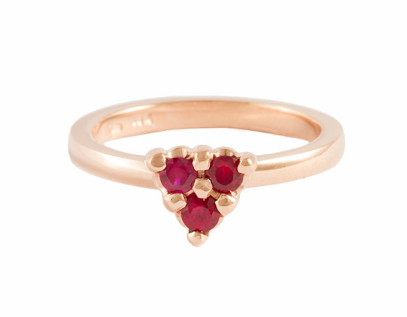 Thin pink gold ring set with three round rich red rubies that form a triangle.  The gems are prong set and sit above the band.