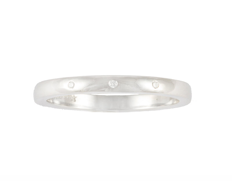 Thin platinum band set with three round diamonds. Gems are set into the band.