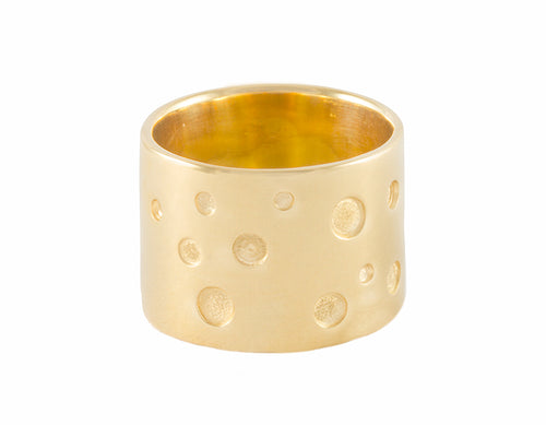 Very wide yellow gold band with scattering of recessed dots of various sizes.