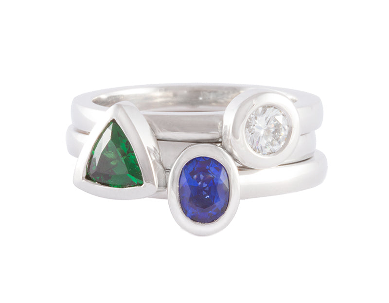 Three platinum rings set with sapphire, tsavorite garnet, diamond.