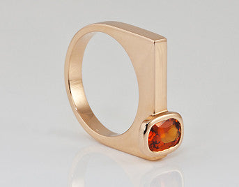 Small rectangle orange gem off-set in rose gold ring.