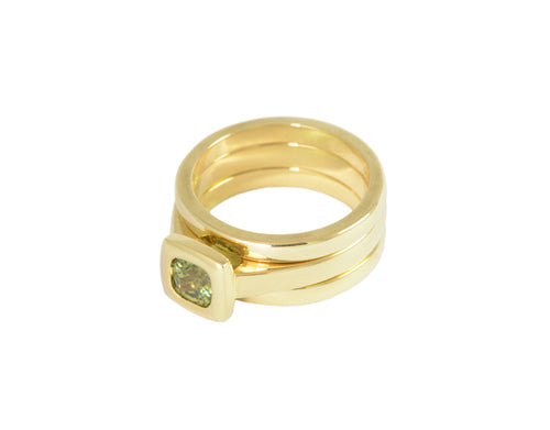 Small square green gem in green gold and matching green gold bands.