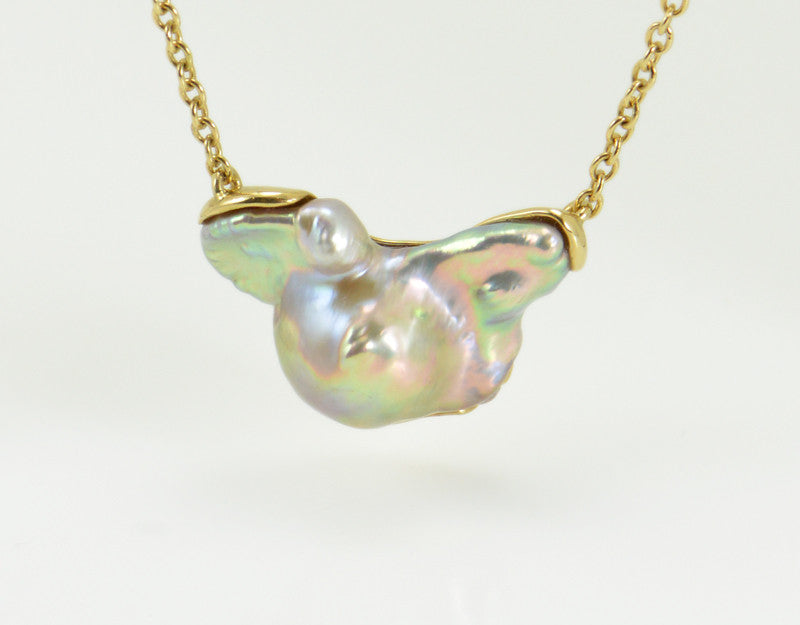 Large free form pearl set in yellow gold and yellow gold chain.