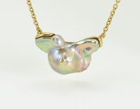 Large free form pearl set in yellow gold and yellow gold chain.