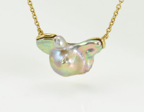 Large free form pearl set in yellow gold and yellow gold chain.