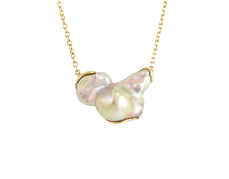 Large free form pearl set in yellow gold and yellow gold chain.