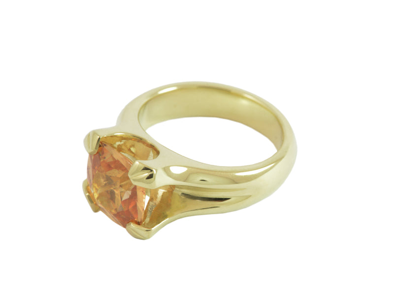 Golden-orange gem cushion shape prong set in green gold ring