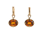 Oval drops with bright orange gems in rose gold frame. Drops hang on small U shaped hoops in solid rose gold.