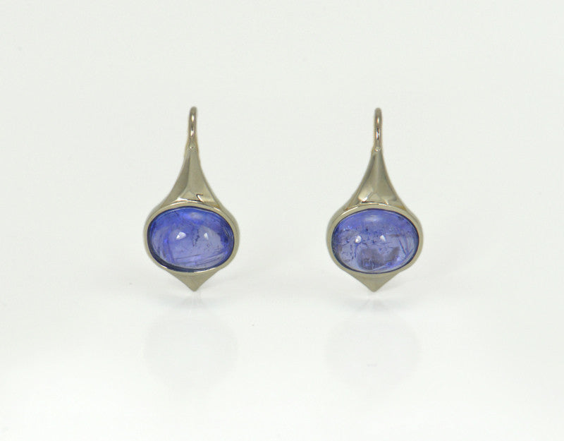 Medium oval purple blue tanzanite cabochons in white gold frame and shepherd's hooks.