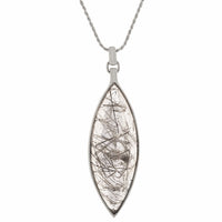 Very long clear gem pointed at two ends illed with black crystal threads in white gold.