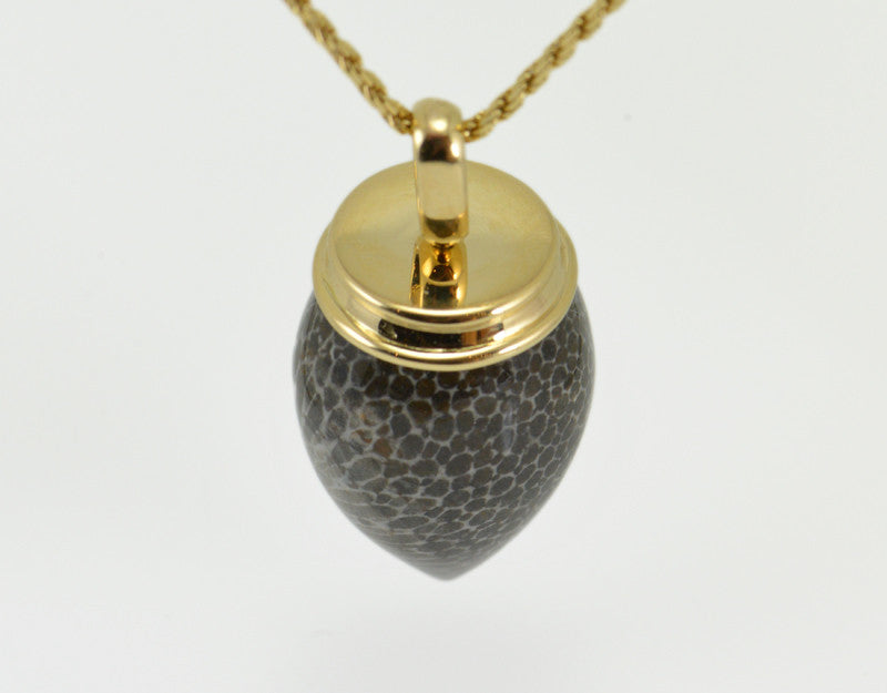 Very long pear shaped gem mottled grey and black with yellow gold cap and chain.