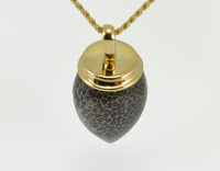 Very long pear shaped gem mottled grey and black with yellow gold cap and chain.