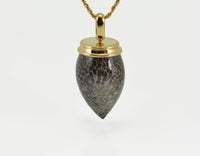 Very long pear shaped gem mottled grey and black with yellow gold cap and chain.