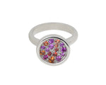 White gold ring set with scattering of pink and orange gems in round face.