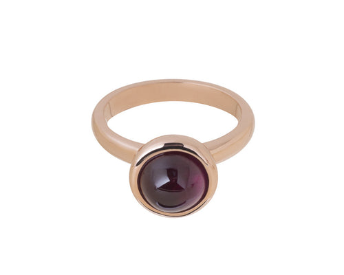 Medium size round cabochon of raspberry red rhodolite frame set in rose gold ring.