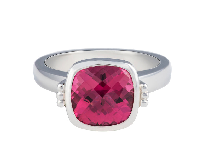 Platinum ring with cushion shaped deep pink gem with checkerboard pattern.