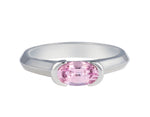 Platinum ring with natural pink sapphire. The sapphire is oval and lies across the finger and is bezel set at two ends.