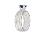Platinum ring set with medium blue spinel with a pair of matching platinum bands.  The spinel is rectangular and prong set and sits above the band.