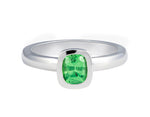 Platinum ring set with a bright apple green tsavorite garnet.  Gem is set in a frame, bezel, rising above the band.