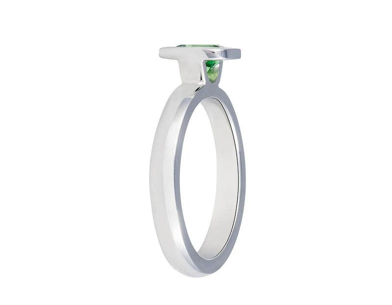 Platinum ring set with a bright apple green tsavorite garnet.  Gem is set in a frame, bezel, rising above the band.