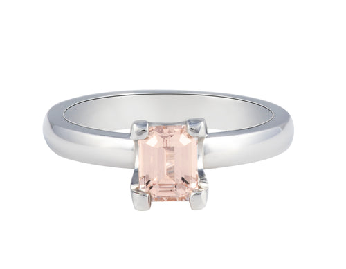 Platinum ring with prong set natural peach coloured sapphire.  Sapphire is slightly rectangular and lies parallel to the finger.