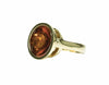 Large green gold ring with large golden brown cabochon gem upside down.