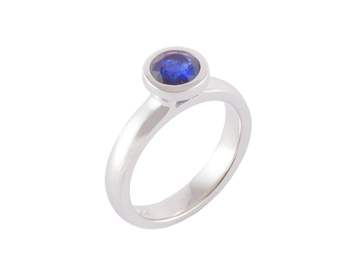Platinum ring with round blue sapphire.