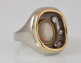 Very large ring in white gold, oval opal and diamonds set inside large bowl, yellow gold rim.