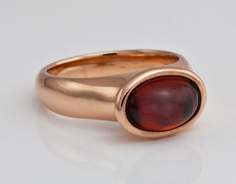 Oval deep red garnet in rose gold ring.