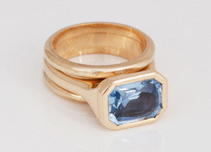Blue gem in yellow gold with matching bands.