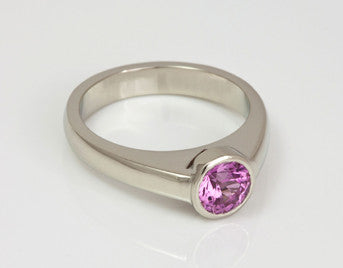 White gold ring with bright pink sapphire.