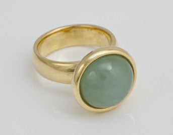 Large round aquamarine cabochon gem in green gold.