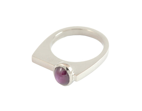 White gold ring with red star sapphire gem.