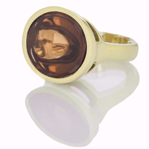 Golden zircon cabochon gem set in green gold ring.