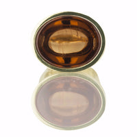 Golden zircon cabochon gem set in green gold ring.