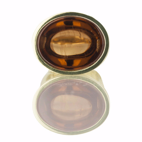 Golden zircon cabochon gem set in green gold ring.