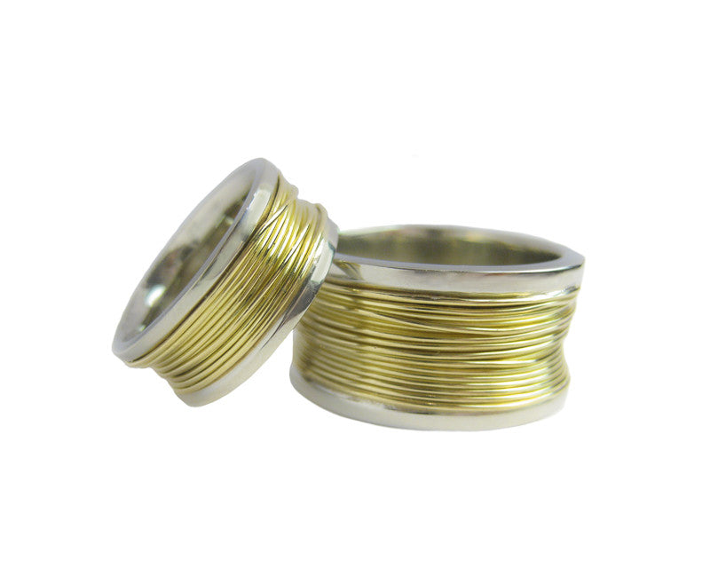 Man's and woman's bands white gold wrapped with yellow gold wire.
