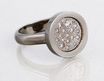 White gold ring with round face set with scattering of diamonds.