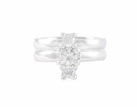 Row of three diamonds, parallel to finger, in platinum ring, and matching band.